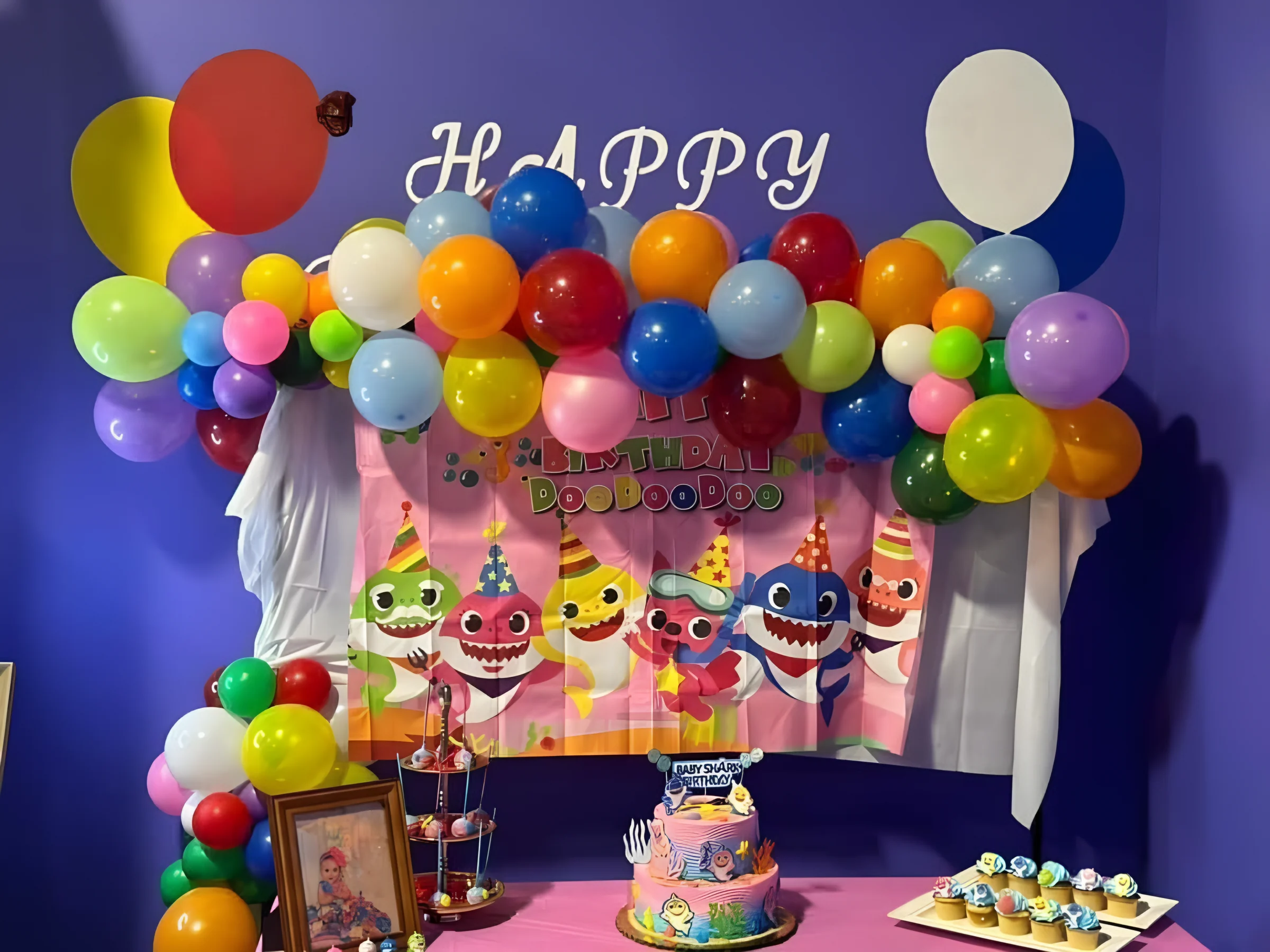 Balloon-arch birthday backdrop and cake in a party room at Nova Adventure Park Cincinnati